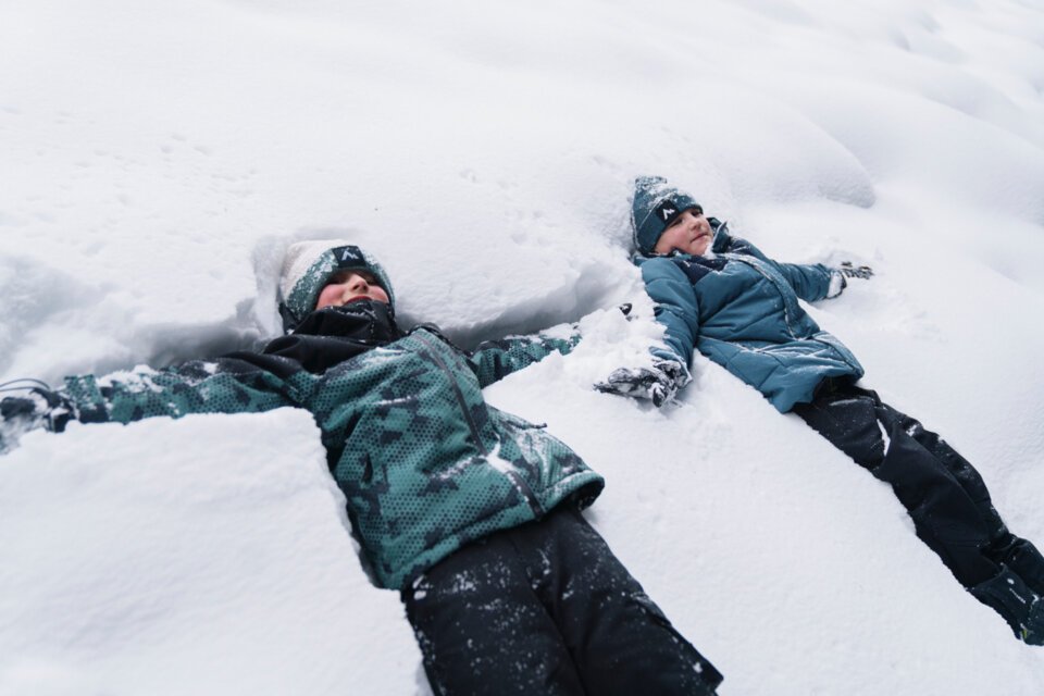 Two children making snow angels in the snow. | © INTERSPORT International Corporation GmbH