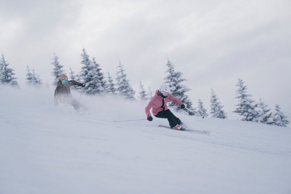 Zwei Skifahrer auf einer verschneiten Piste | © INTERSPORT International Corporation GmbH