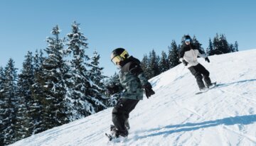 Two snowboarders on a snowy slope