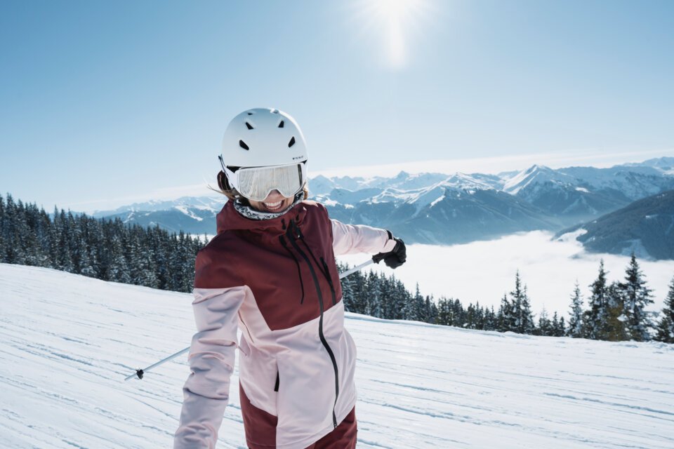 Frau beim Skifahren im Schnee mit Bergen im Hintergrund. | © INTERSPORT International Corporation GmbH