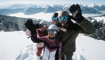 Group of four skiers waving in the mountains. | © INTERSPORT International Corporation GmbH