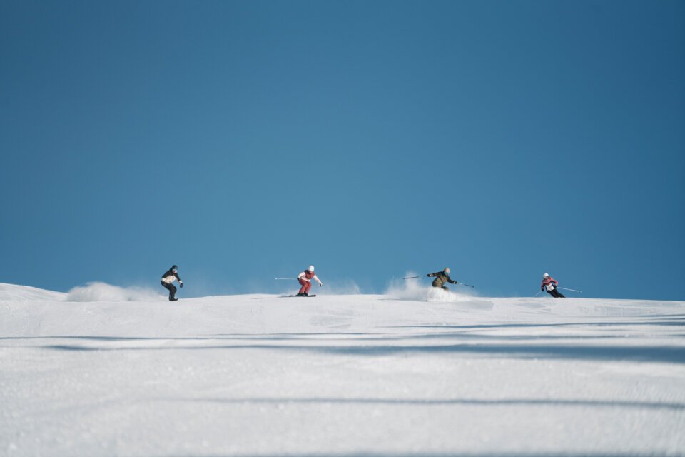 Group of skiers on a snowy slope under a blue sky. | © INTERSPORT International Corporation GmbH
