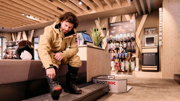 Mann probiert Snowboardstiefel in einem Geschäft an. | © ARMIN WALCHER