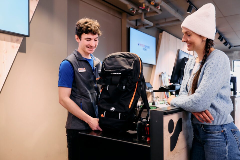 © ARMIN WALCHER Verkäufer zeigt Kundin einen Mammut-Rucksack in einem Sportgeschäft. | © ARMIN WALCHER