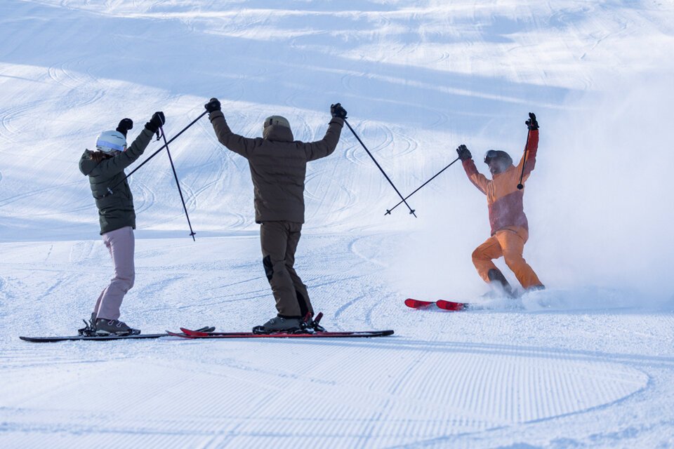 Three skiers cheering on a snow-covered slope. | © INTERSPORT International Corporation GmbH