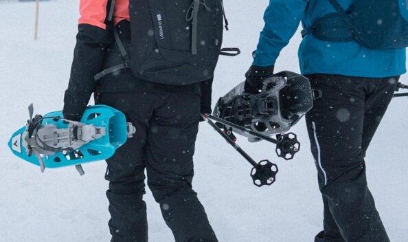 Zwei Personen gehen mit Schneeschuhen und Rucksäcken im Schnee. | © IIC/McKINLEY