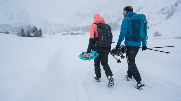 Zwei Personen mit Schneeschuhen wandern in verschneiter Landschaft. | © IIC/McKINLEY