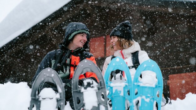 Zwei Personen mit Schneeschuhen im Schnee.