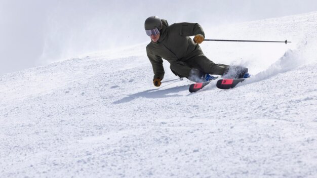 Skier skiing down a snowy slope.