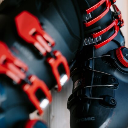 Nahaufnahme von schwarzen Skischuhen mit roten Schnallen und BOA-System.
