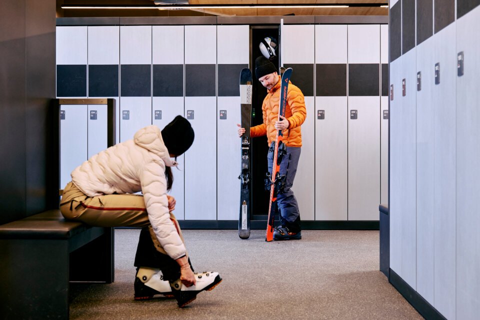 Zwei Personen bereiten sich in einem Skiraum vor. | © ARMIN WALCHER