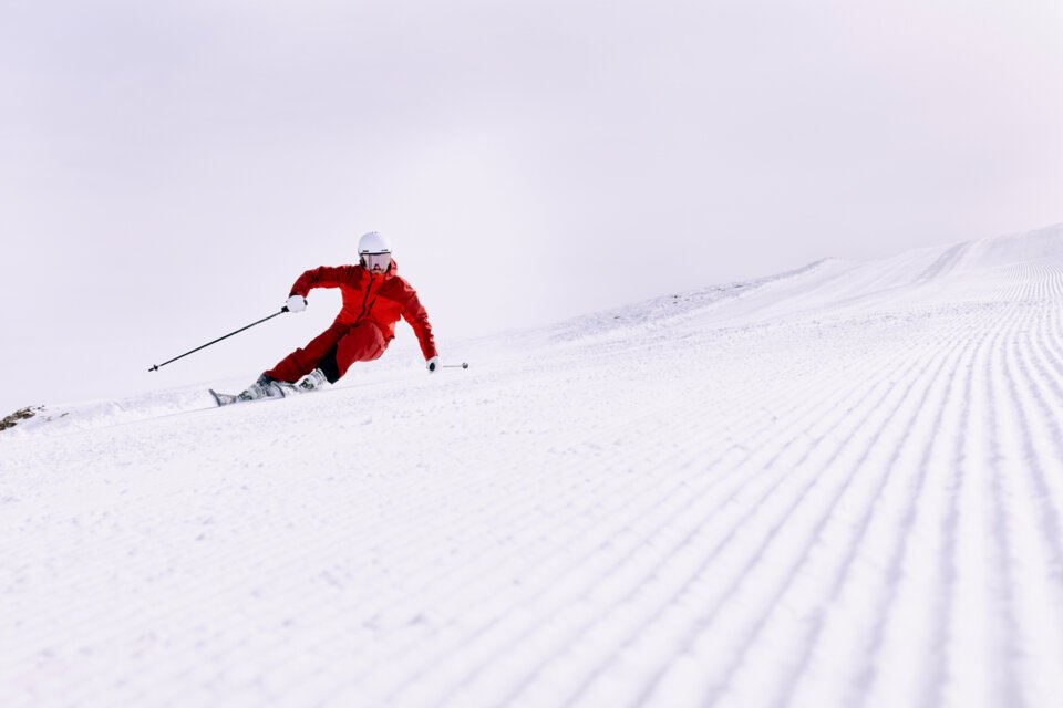 Skier in red outfit on snowy piste. | © ARMIN WALCHER