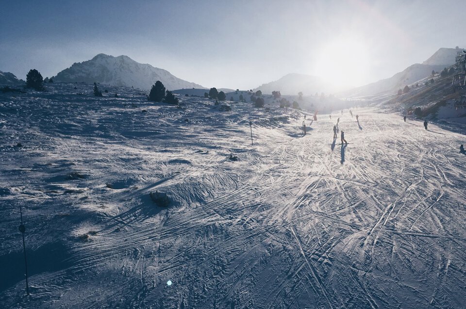 Skiers on a snow-covered slope in the mountains.