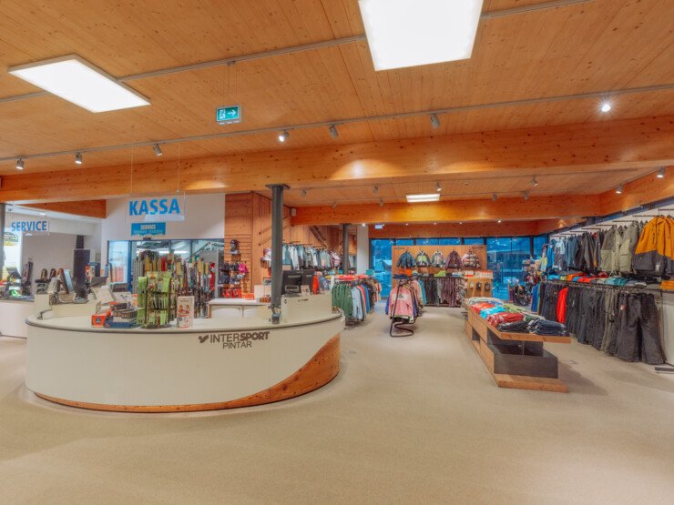 Spacious sports shop interior with checkout area, clothing and equipment displayed across the rental location interior