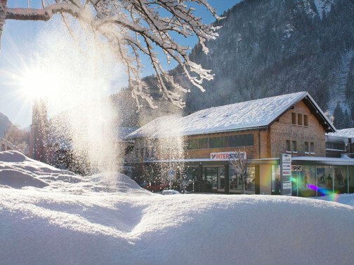 Intersport-Geschäft in einem Tal in verschneiter Winterlandschaft
