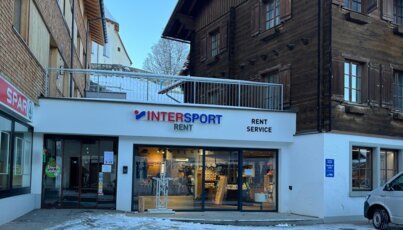 Fassade eines INTERSPORT Rent-Geschäfts in einer winterlichen Ortsmitte.