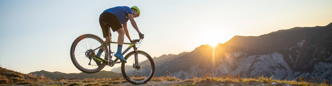 Mountainbiker auf Hardtail bei Sonnenuntergang