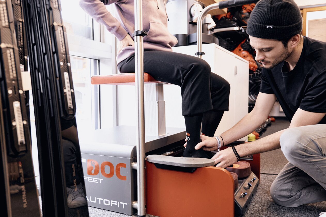 Man fitting ski boot for customer.